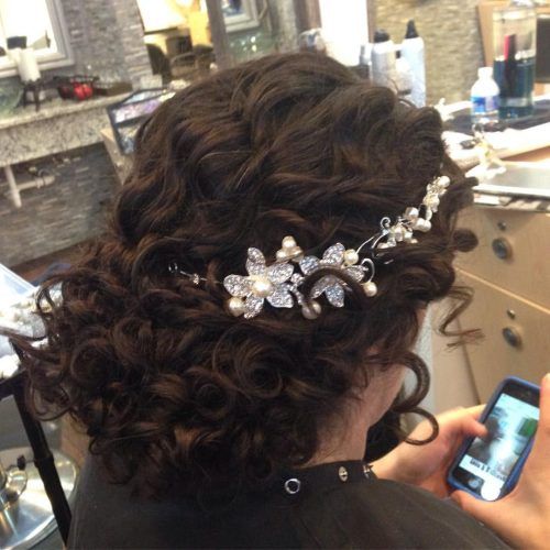Wavy Low Bun Bridal Hairstyles With Hair Accessory (Photo 11 of 20)
