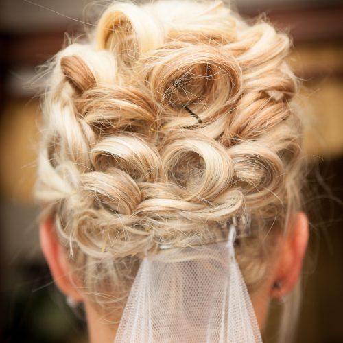 Large Curly Bun Bridal Hairstyles With Beaded Clip (Photo 6 of 20)